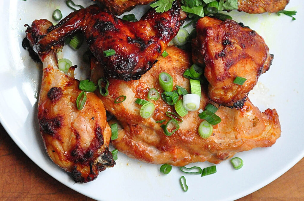 gochujang rubbed roast chien on a white plate with scallions