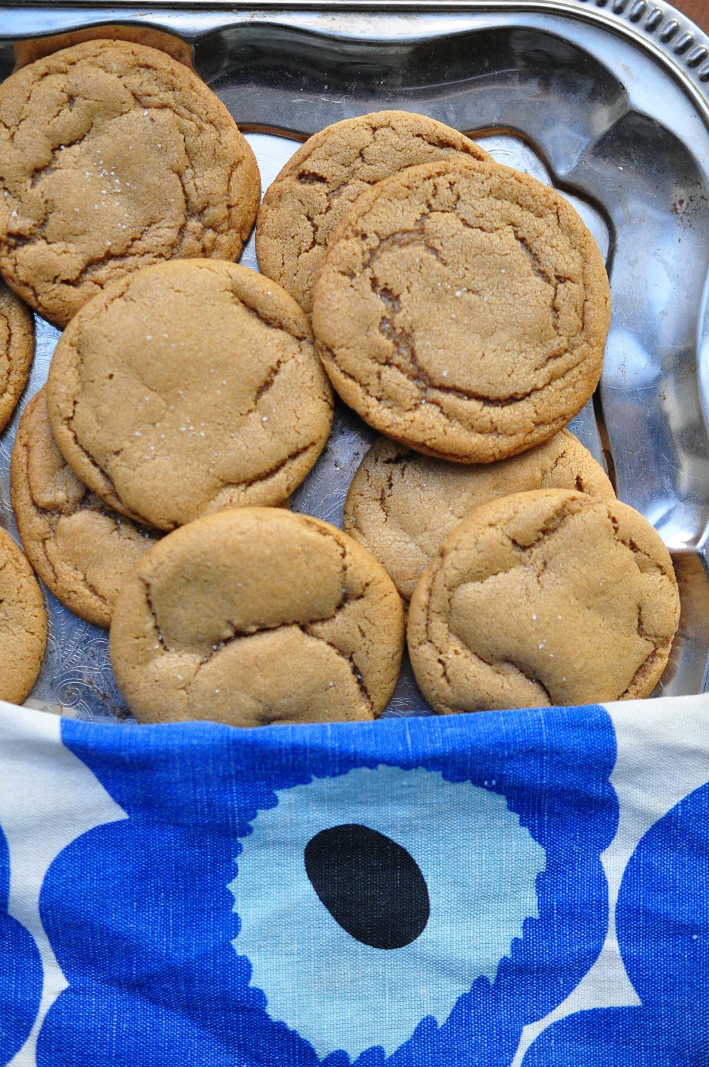 soft nutmeg cookies on a silver tray with blue flower dish towel