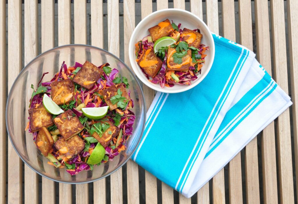 large bowl and small bowl of banh mi salad with dish towel