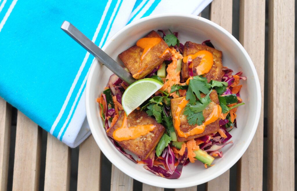 bowl of banh mi salad with spoon and lime slice