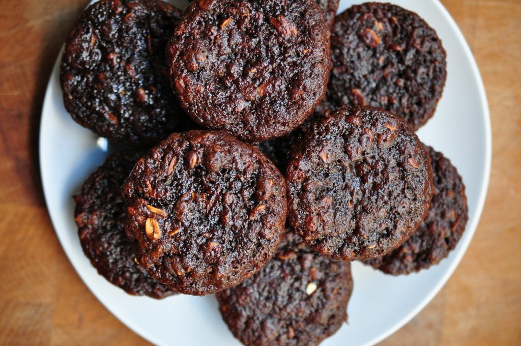 chocolate zucchini muffins piled on a white plate