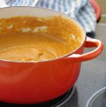orange pot with sweet potato soup inside