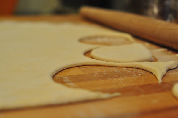 perogy dough rolled out with pieces cut out