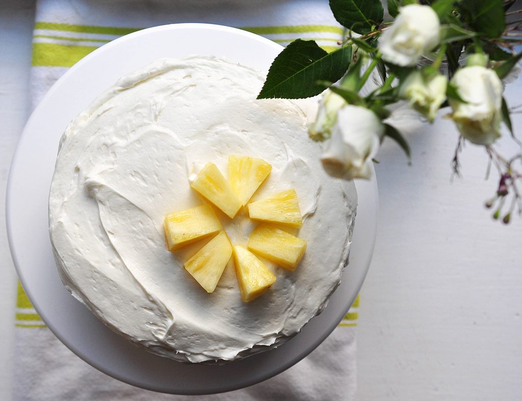 Carrot-pineapple cake with cream cheese frosting from the top with flowers