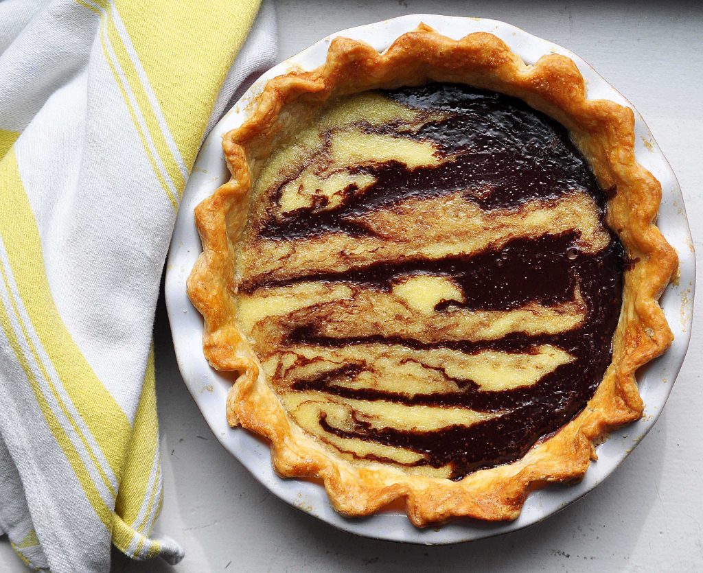 coconut chocolate swirl pie in dish with yellow dish cloth beside