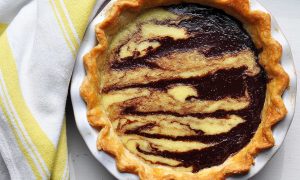 coconut chocolate swirl pie in dish with yellow dish cloth beside
