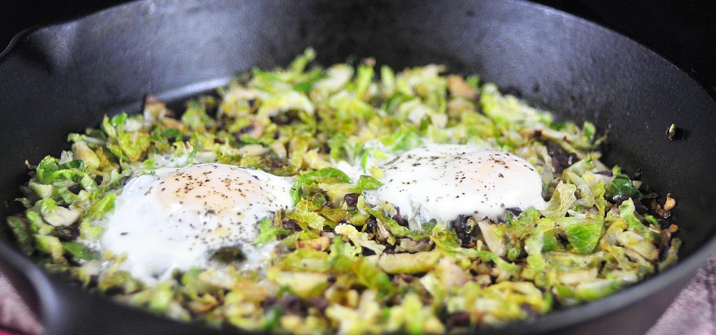 cast iron pan with brussels sprouts hash and eggs