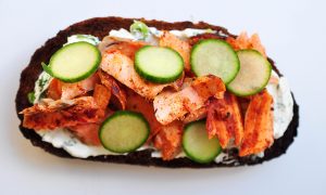 pumpernickel bread with smoked paprika rubbed salmon, cucumbers and dill cream cheese