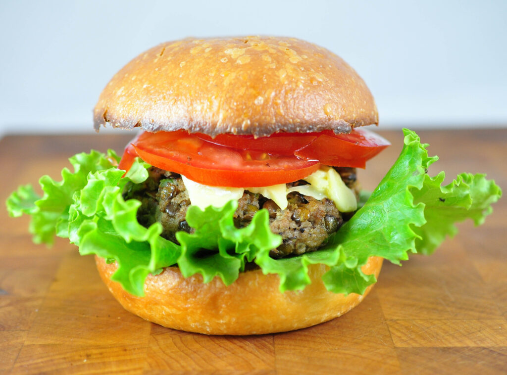 half veggie burger with a beautiful fluffy lettuce and tomato on top